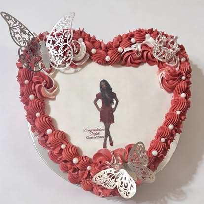 Heart-shaped cake in deep red buttercream with silver butterflies and an edible photo
