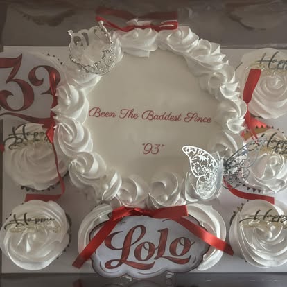 Celebration cake ringed by cupcakes finished in the same design
