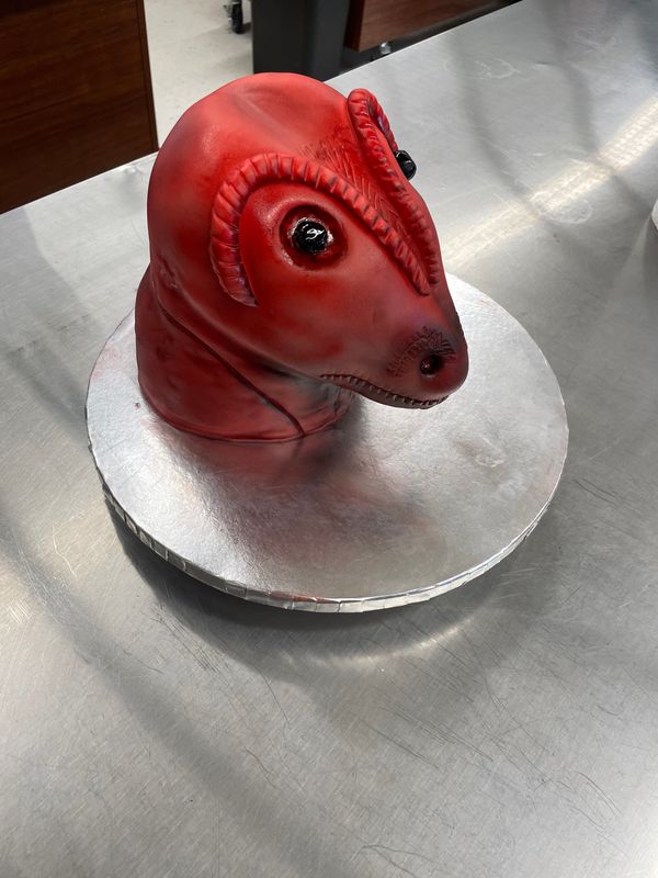 Sculpted red dinosaur head cake