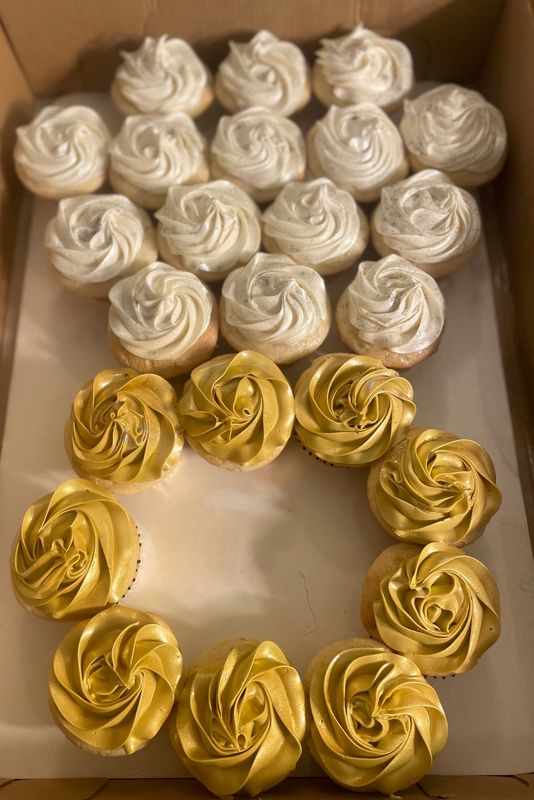 Cupcakes piped in white and gold, arranged as an engagement ring