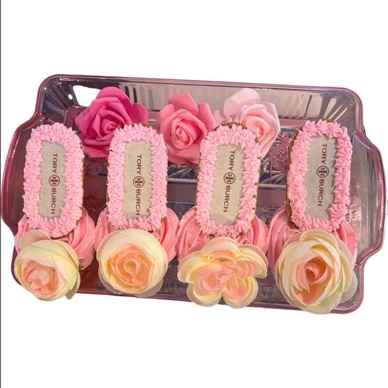 Pink cupcakes with edible printed logo toppers, boxed with flowers as a gift