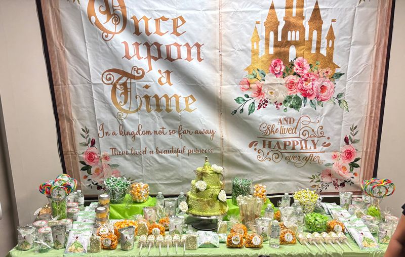 Once upon a time storybook dessert table with a tiered cake and treats